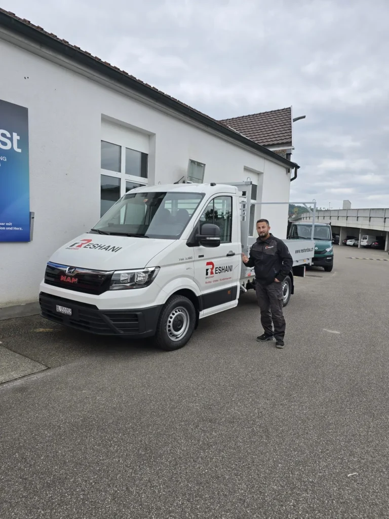 Mitarbeiter der RESHANI Bau vor dem Firmenfahrzeug